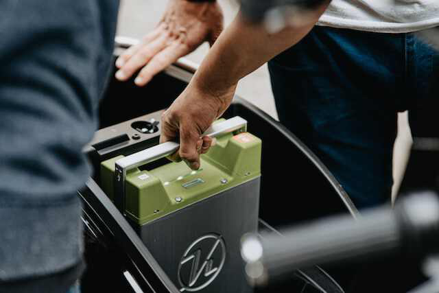 a hand hold a portable car battery