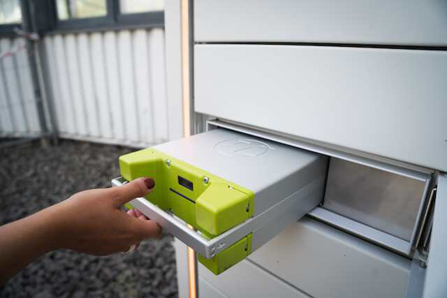 a hand putting a battery into the charging station