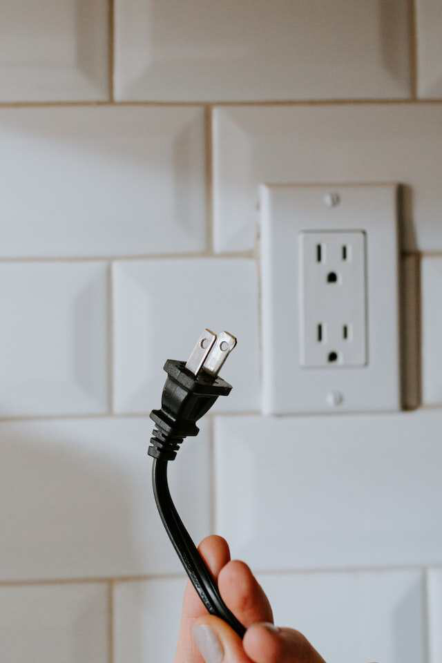 a hand holding a electric plug